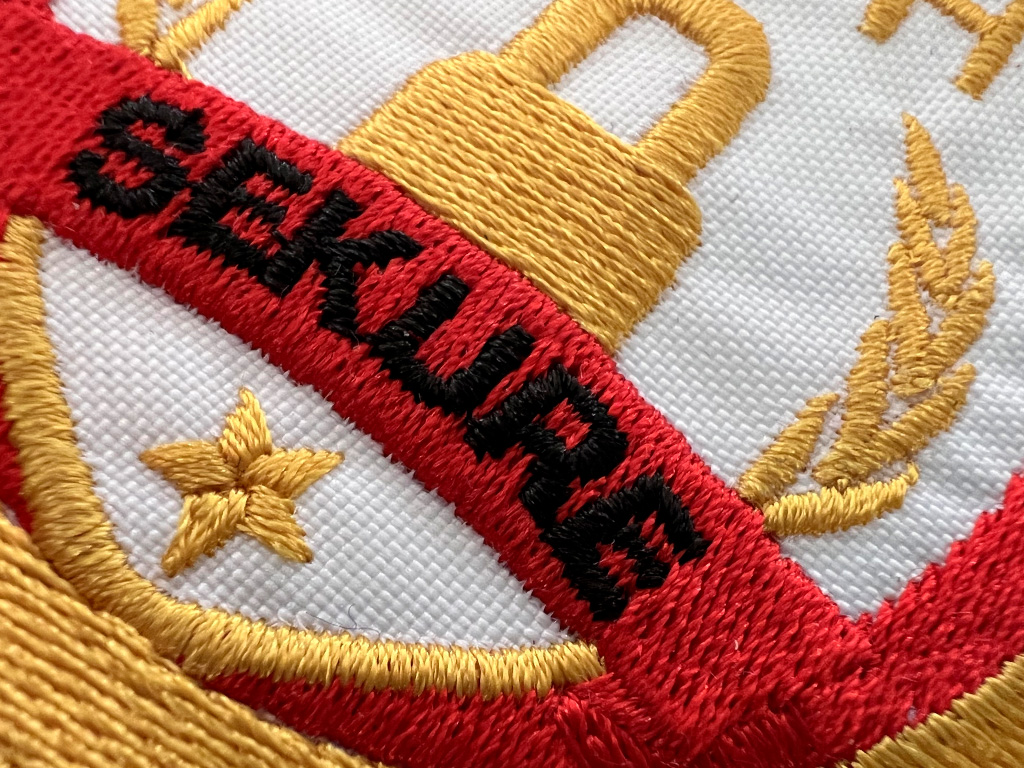 Logotipo Sekure bordado en oro sobre una gorra