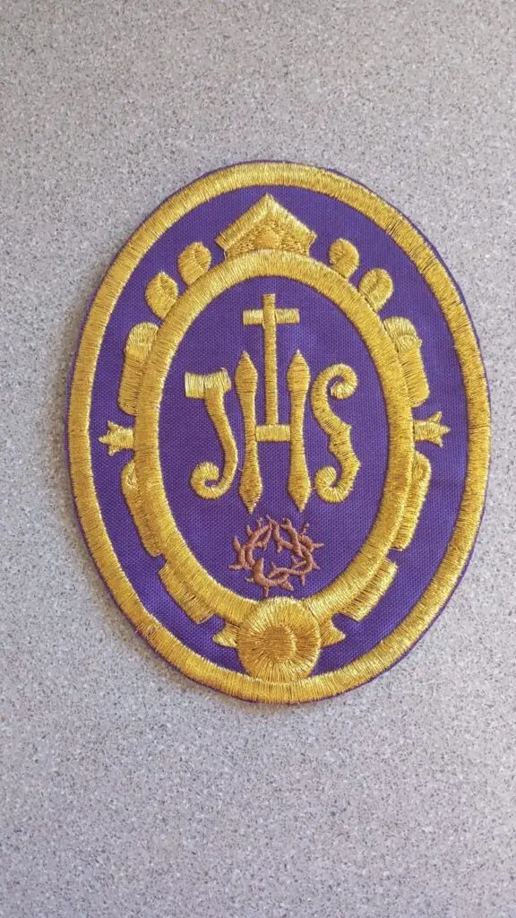 Emblema JHS bordado en oro sobre morado